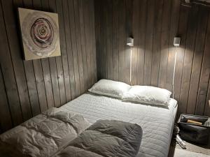 Un dormitorio con una cama y una pared de madera. en Casa Blanca, en Å i Åfjord