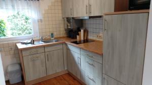 a kitchen with wooden cabinets and a sink and a window at Ferienhaus zur Dorfbachklamm in Altendorf
