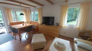 a living room with a table and a television at Ferienhaus zur Dorfbachklamm in Altendorf