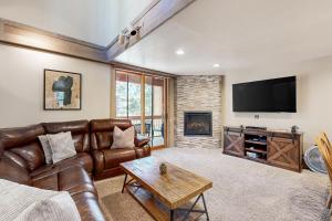 een woonkamer met een leren bank en een flatscreen-tv bij Gold Bend Adventure in Truckee