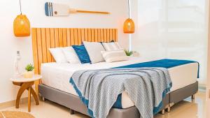 a bed with a blue and white blanket on it at apartamento luxury, Frente al mar in Gaira +11 photos