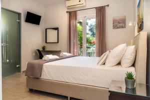 a bedroom with a large bed and a window at Maria Olga Apartments in Benitses