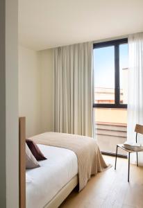 a bedroom with a bed and a large window at Archie Living in Barcelona +66 photos