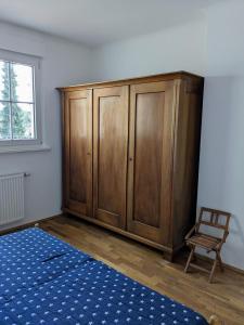 a large wooden cabinet in a room with a chair at Ferienwohnung in alter Villa in Neukirch +18 photos