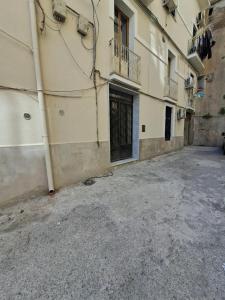 een leeg steegje met een deur in een gebouw bij ti Porto al Centro Unforgettable Moments in Salerno
