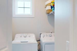 una cucina con piano cottura, lavatrice e asciugatrice di Docs Boardwalk a Kure Beach