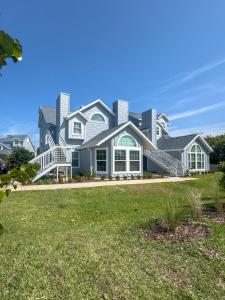 a large house with a large lawn in front of it at Beachside Elegance: Pool Spa Luxury Retreat Sun Beach Club 888 in Edgewater
