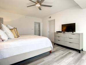 une chambre blanche avec un lit et une télévision à écran plat dans l'établissement Beautifully decorated oceanfront 33 corner unit in Ocean Condo 401, à New Smyrna Beach
