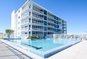 un grand immeuble d'appartements avec une grande piscine dans l'établissement Beautifully decorated oceanfront 33 corner unit in Ocean Condo 401, à New Smyrna Beach