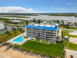 une vue aérienne d'un complexe hôtelier sur la plage dans l'établissement Beautifully decorated oceanfront 33 corner unit in Ocean Condo 401, à New Smyrna Beach