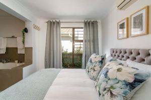 a bedroom with a large bed and a window at Chic, Cozy, Modern, Secure and Centrally Located in Cape Town