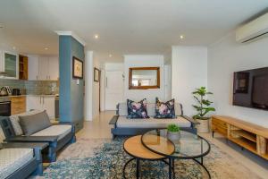 a living room with two couches and a table at Chic, Cozy, Modern, Secure and Centrally Located in Cape Town