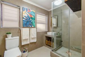 a bathroom with a shower and a toilet and a sink at Chic, Cozy, Modern, Secure and Centrally Located in Cape Town +17 photos