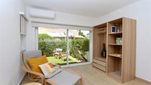 - un salon avec une chaise et une porte coulissante en verre dans l'établissement Fig Villa- CleverDetails, Sleep 8, Pool, Children Playground, Ténis court, à Vilamoura