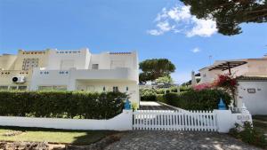 une clôture blanche devant une maison blanche dans l'établissement Fig Villa- CleverDetails, Sleep 8, Pool, Children Playground, Ténis court, à Vilamoura