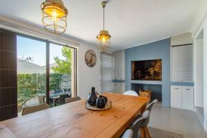 a dining room with a wooden table and a large window at Chic, Cozy, Modern, Secure and Centrally Located in Cape Town