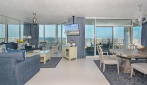 a living room with a couch and a table at Ocean Condo 104 ~ Ground Floor Corner Condo with wrap around balcony Walk right out to Pool in New Smyrna Beach