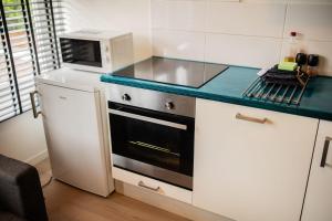 a small kitchen with a stove and a microwave at Amazing 50m2 Two-Bedroom Apartment - TS307A in Eindhoven +32 photos