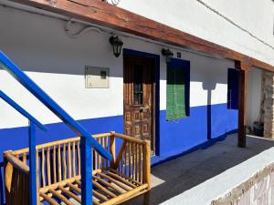 a blue and white building with a door and stairs at Cueva de la Abuela María in Alcalá del Júcar