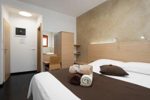 una camera da letto con un grande letto con asciugamani di Boutique Wrungel a Vrsar