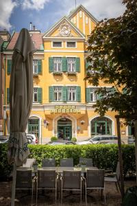 stół z parasolem przed budynkiem w obiekcie Hotel Bergwirt Schönbrunn w Wiedniu