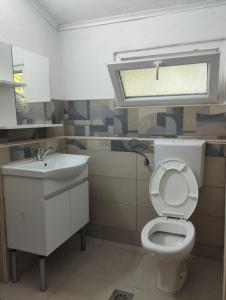 a bathroom with a toilet and a sink and a window at Vila Katerina Dojran in Sretenovo