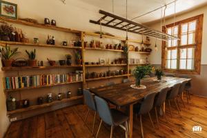 a dining room with a table and chairs and bookshelves at Puszcza - Przestrzeń Kreatywna in Andrzejów