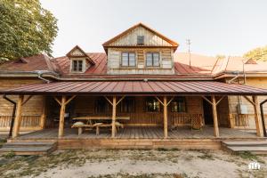 a wooden house with a table on a deck at Puszcza - Przestrzeń Kreatywna in Andrzejów