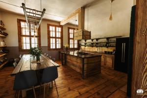 a large kitchen with a large wooden table and chairs at Puszcza - Przestrzeń Kreatywna in Andrzejów