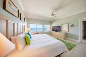 sypialnia z dużym łóżkiem i telewizorem w obiekcie Palmetto Beachfront Hotel, a By The Sea Resort w mieście Panama City Beach