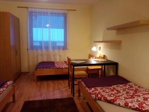 Cette chambre comprend un bureau, une table et une fenêtre. dans l'établissement ROKOSZ - Noclegi Beskid Niski, à Sękowa