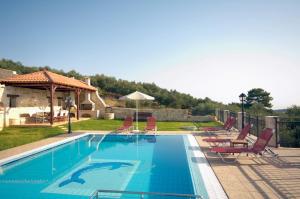 a swimming pool with chairs and a gazebo at Dream Hill Villas in Tavronitis