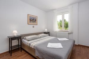 sypialnia z łóżkiem i dwoma ręcznikami na nim w obiekcie Apartments Villa Temer w mieście Pinezići