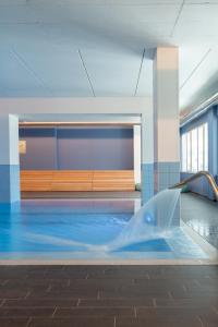 洛阿諾的住宿－Ai Pozzi Village Resort & SPA，一座大楼内带水滑梯的游泳池