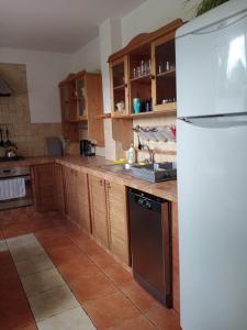 une cuisine avec des armoires en bois et un réfrigérateur blanc dans l'établissement ROKOSZ - Noclegi Beskid Niski, à Sękowa