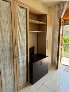 Zimmer mit einem Kleiderschrank, einem TV und einem Schreibtisch. in der Unterkunft Family house in Volla
