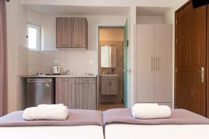 a kitchen with two towels on top of a bed at Maria Olga Apartments in Benitses