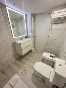 a bathroom with a toilet and a sink and a mirror at Mediterranea Loft New in La Pineda