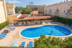 a pool with chairs and people swimming in it at Mediterranea Loft New in La Pineda