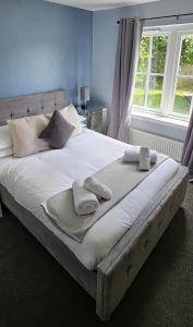 a large bed with pillows on it in a bedroom at Balmaha Lodges and Apartments in Balmaha