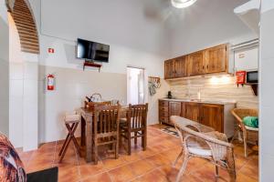 a kitchen and dining room with a table and chairs at Casa da Ti Inácia - Praia Azenhas D El Rey in Montes Juntos