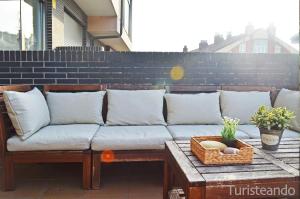 a couch sitting on a patio with a table at La Casuca del Farolillo - con parking y terraza primera línea de playa in San Vicente de la Barquera