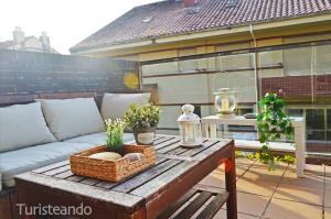 a coffee table with a couch on a patio at La Casuca del Farolillo - con parking y terraza primera línea de playa in San Vicente de la Barquera
