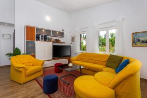 salon z 2 żółtymi kanapami i telewizorem w obiekcie Apartments Villa Temer w mieście Pinezići
