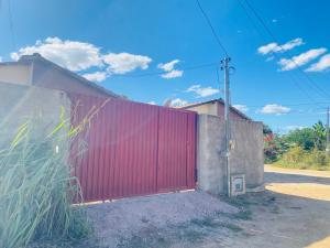 una puerta roja en el lateral de un edificio en Tranquilidade na Chapad dos Veadeiros, en Cavalcante