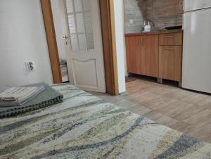 a room with a bed and a kitchen with a door at Vila Katerina Dojran in Sretenovo