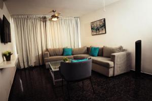 a living room with a couch and a table at Residenciales H1 & H2 - Breakfast & Room Service - Airport close in Santiago de los Caballeros