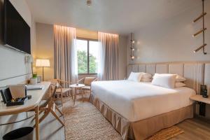 um quarto de hotel com uma cama grande e uma secretária em Only YOU Hotel Málaga em Málaga