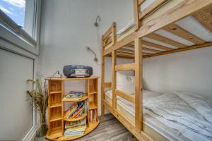 ein Schlafzimmer mit einem Etagenbett und einem Bücherregal in der Unterkunft Ferienpark - Haus H, App 0H0501 in Heiligenhafen