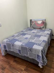 uma cama com uma colcha azul e branca em Vilage Bed & Breakfast em Volta Redonda